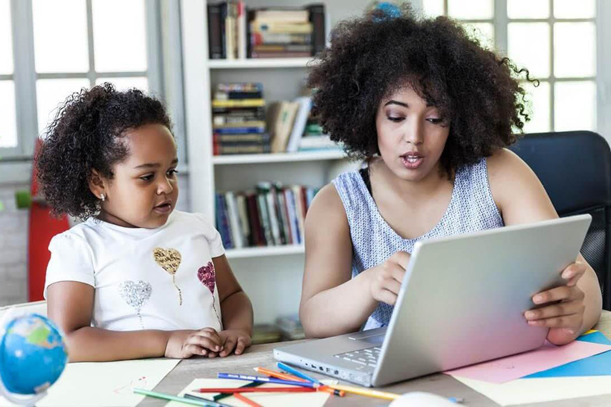Parent teaching kid on a computer