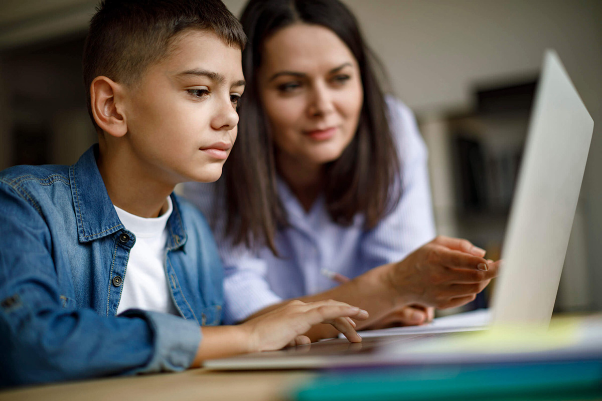 Parent teaching kid on a computer